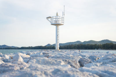 Street light on snow covered land against sky