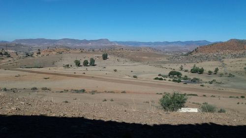 Scenic view of desert against clear blue sky