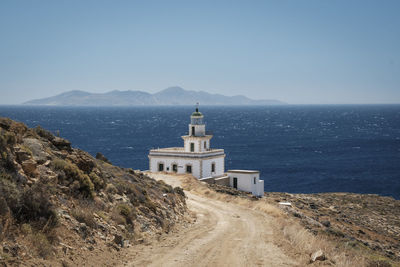 Lighthouse by sea against sky