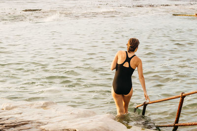 Rear view of woman standing on beach