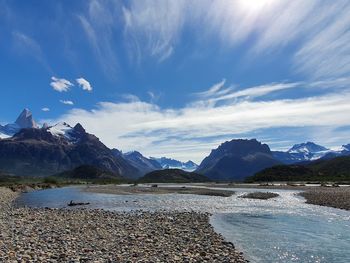 Scenic view of lake by mountains against sky