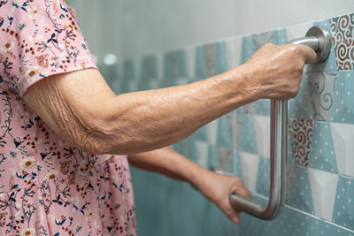 Asian senior woman patient use toilet bathroom handle security concept.