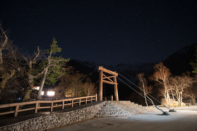 Illuminated bridge against sky at night