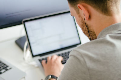 Rear view of man using laptop