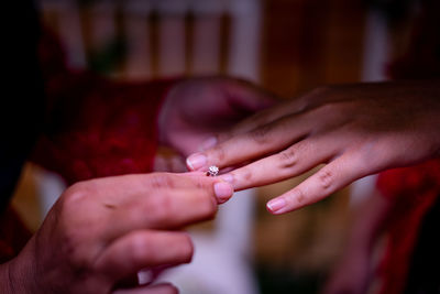 Close-up of couple exchanging rings during wedding ceremony