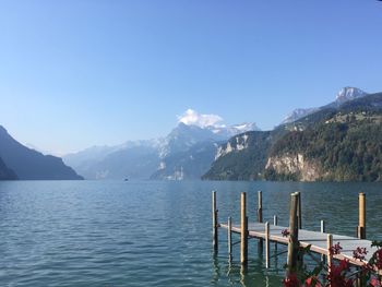 Scenic view of lake and mountains against blue sky