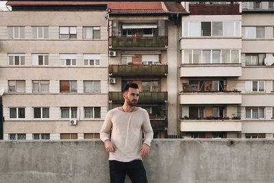 Man standing against building in city