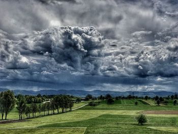 Scenic view of field against cloudy sky