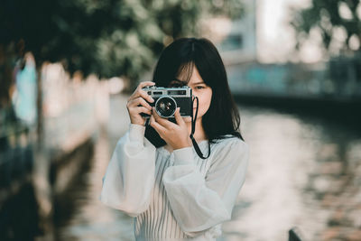 Portrait of young woman photographing