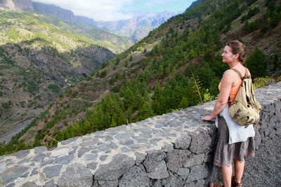 Full length of woman with arms raised on mountains