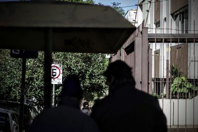 Rear view of two people in front of building