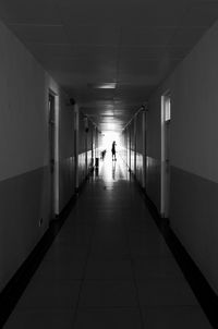 Rear view of people walking in corridor of building