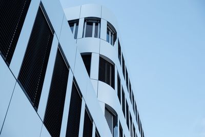 Low angle view of modern building against clear blue sky