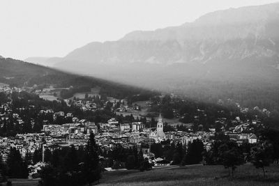 Scenic view of townscape by mountains against sky