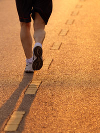 Low section of man running on road