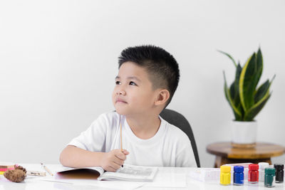 Portrait of boy sitting on table