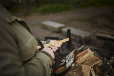 Person carving wooden stick