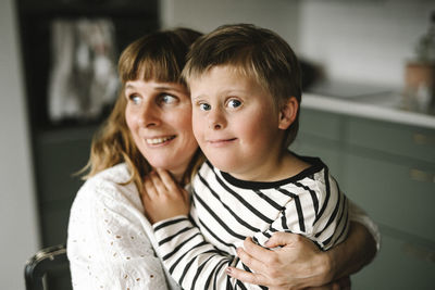 Portrait of boy having down syndrome with mother at home