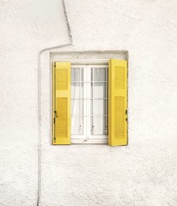 Low angle view of yellow window on white wall