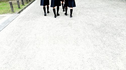 Low section of women walking on road