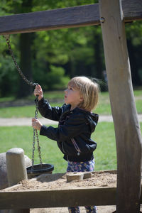 Side view of girl holding playground