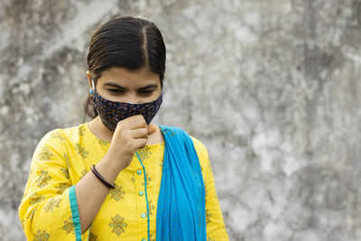 Health problem and people concept - unhealthy indian woman coughing with nose mask on