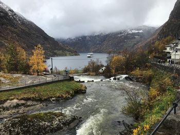 Scenic view of river by mountains against sky