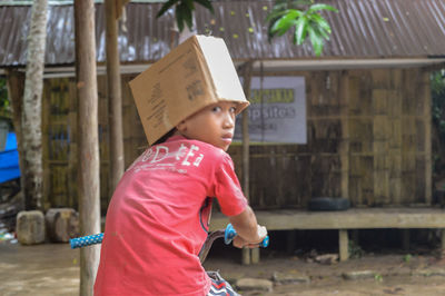 Side view of boy standing against wall