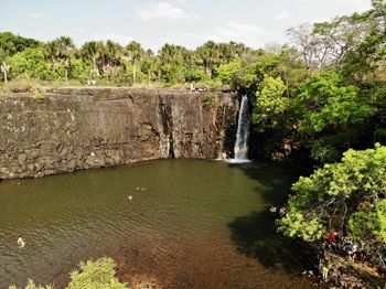 Scenic view of waterfall in forest against sky