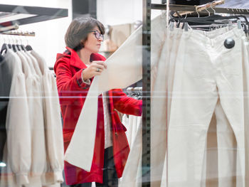 Woman chooses trousers at clothing store. casual trousers hanging on hangers.shopping at mall. 