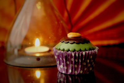 Close-up of halloween cupcake and candle on table