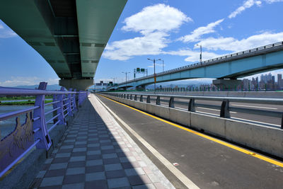 Bridge over river in city against sky