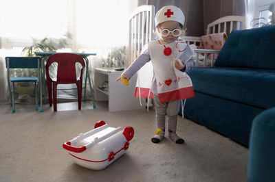 Boy with toy while standing at home