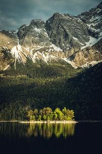 Scenic view of alpine lake and mountains against sky during sunset