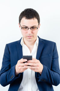 Young man using smart phone against white background