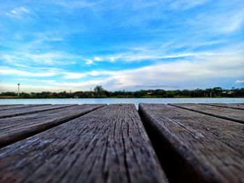 Surface level of boardwalk against blue sky