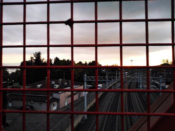 Metal fence against sky during sunset