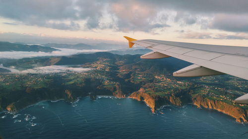 Airplane flying over sea against sky