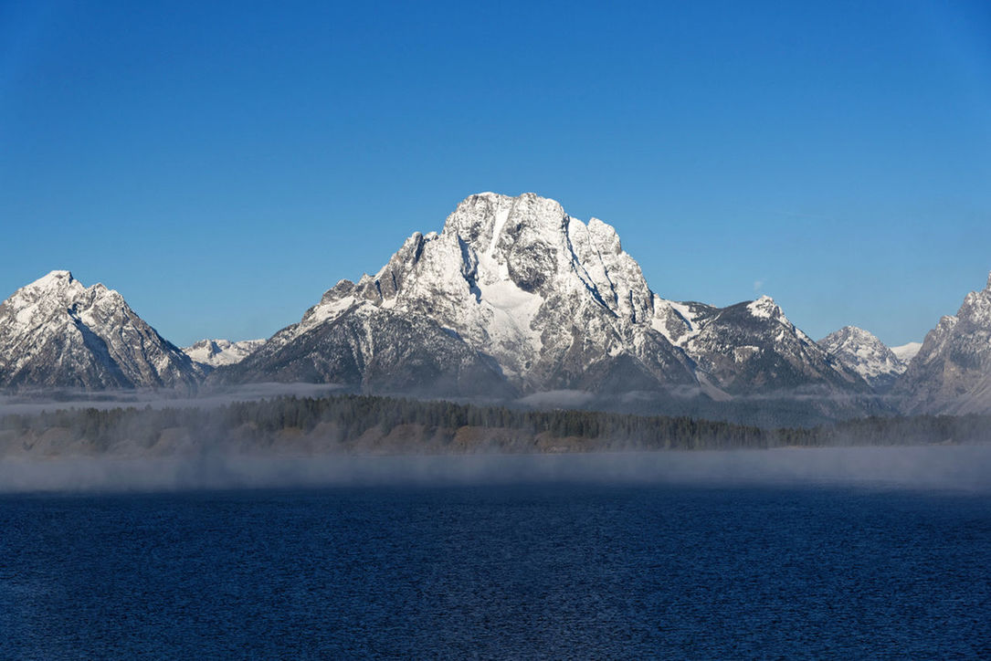 SCENIC VIEW OF LAKE AND SNOWCAPPED MOUNTAINS AGAINST BLUE SKY