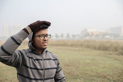 Young man looking away on field