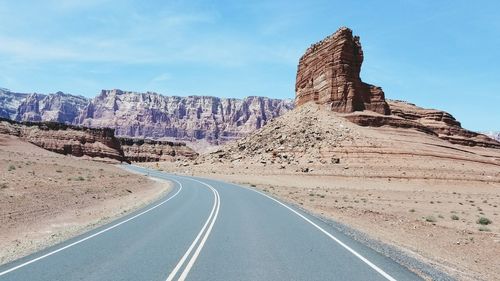 Road by rock formation against sky