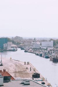 High angle view of buildings by river against clear sky