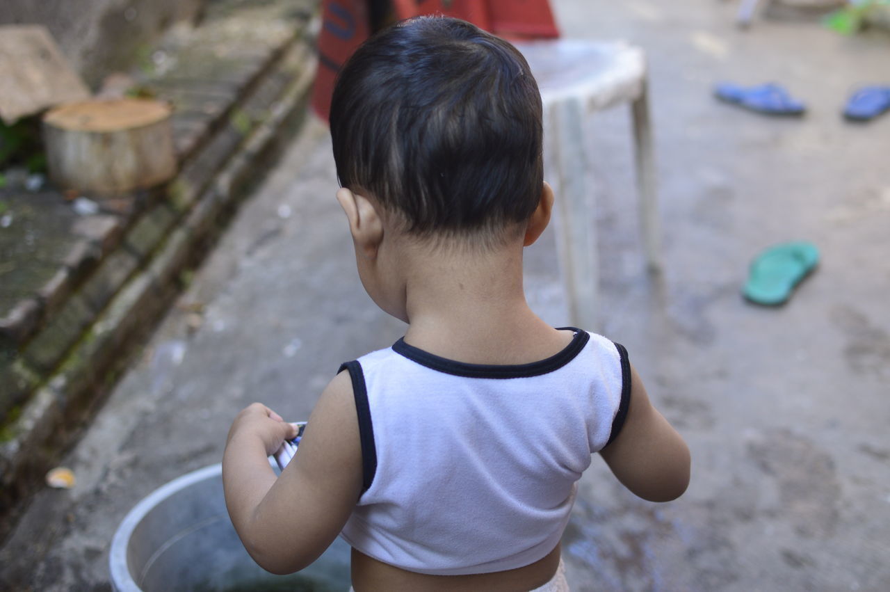 REAR VIEW OF CHILD STANDING OUTDOORS