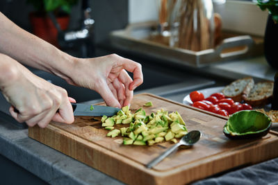 Woman chopping avocado for breakfast toasts