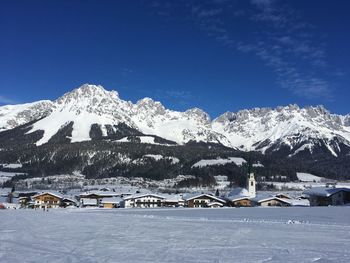 Scenic view of snowcapped mountains against blue sky