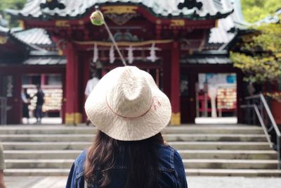 Rear view of woman with umbrella walking on staircase