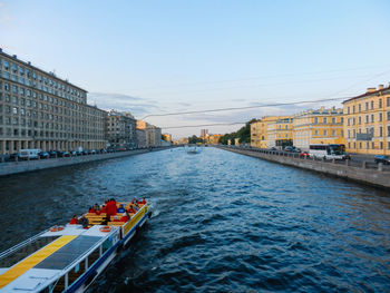 Scenic view of river by buildings against sky
