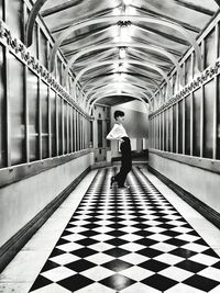 Full length rear view of woman standing in corridor