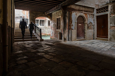 Rear view of man walking on footpath