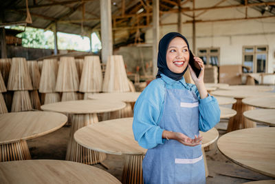 Portrait of smiling young woman standing at restaurant